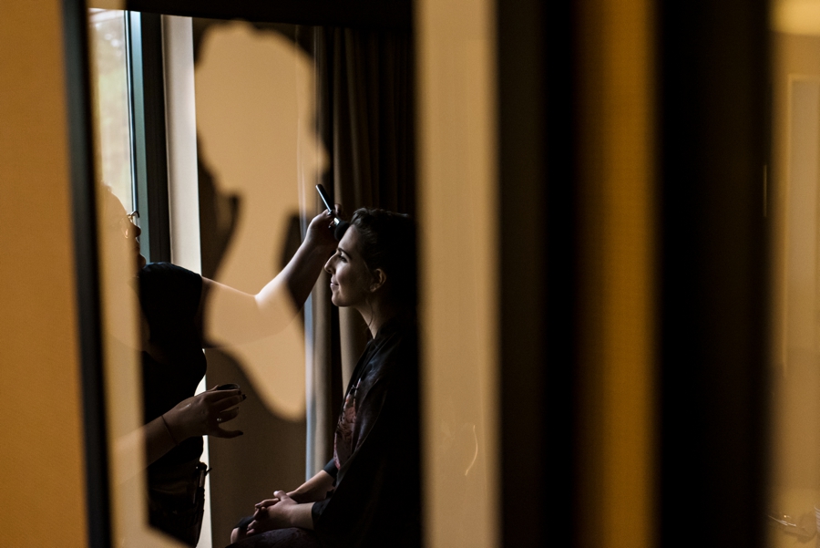 A reflection of a bride getting her makeup done before the wedding in Philadelphia.